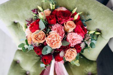 Gelin buketi şeftali ve kırmızı Güllü ve uzun yeşil koltukta şerit