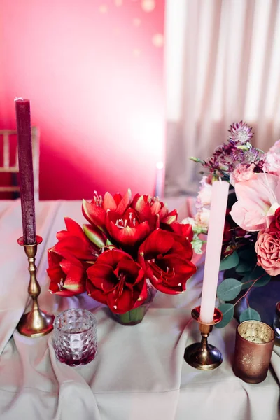 Área decorada em ouro e cores borgonhas com velas e flores brancas — Fotografia de Stock