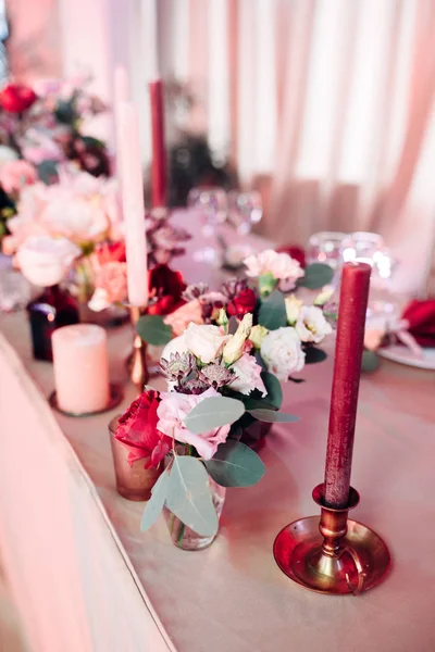 Área decorada em ouro e cores borgonhas com velas e flores brancas — Fotografia de Stock