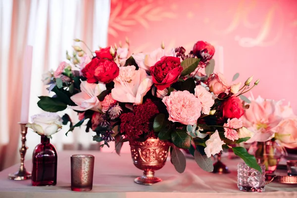 Área decorada em ouro e cores borgonhas com velas e flores brancas — Fotografia de Stock