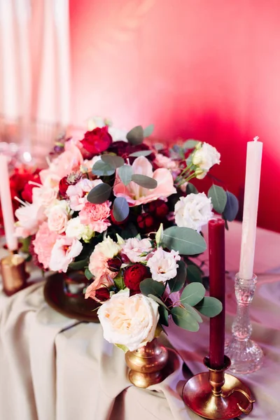 Área decorada em ouro e cores borgonhas com velas e flores brancas — Fotografia de Stock