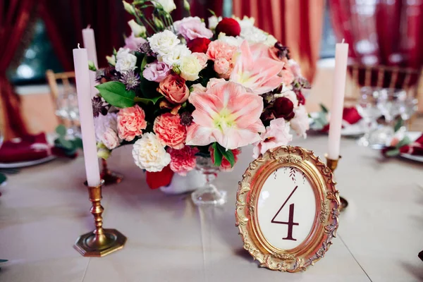 Área decorada em ouro e cores borgonhas com velas e flores brancas, com número de tabela — Fotografia de Stock