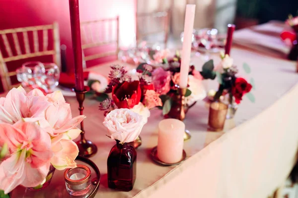 Área decorada en colores oro y burdeos con velas y flores blancas —  Fotos de Stock