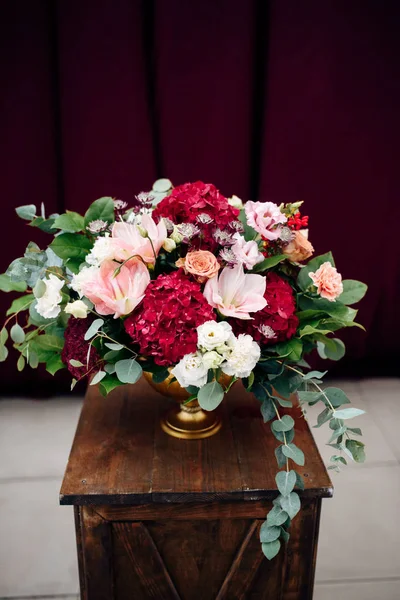 Роскошный букет с белыми и фиолетовыми цветами в вазе на деревянном подставке — стоковое фото