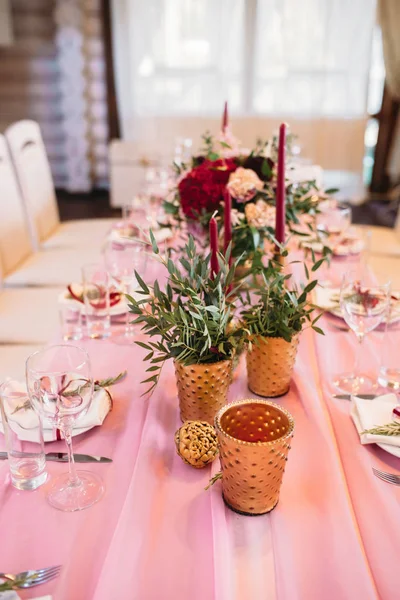 Mesas para invitados decoradas en color rosa con flores, velas, jarrones de oro y eucalipto —  Fotos de Stock