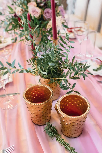 Две золотые вазы на украшенном свадебном столе с эвкалиптом и бургундскими цветами — стоковое фото