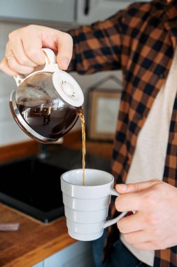 Kafkasyalı bir adam bir fincana kahve dolduruyor.