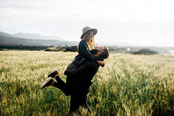 Stylish casual couple on a green field — Stock Photo, Image