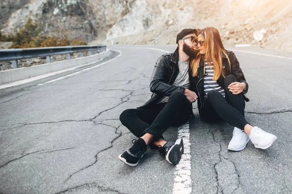 Couple heureux amoureux assis sur la route — Photo