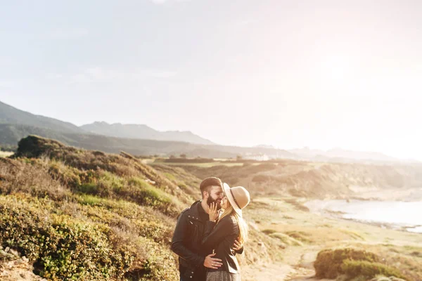 Jeune couple debout sur un rocher, étreignant — Photo