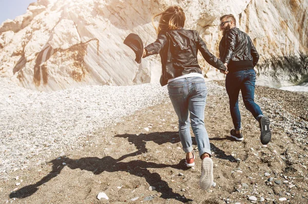 Feliz pareja en las chaquetas de cuero corriendo en —  Fotos de Stock