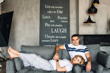 Gri kanepede bir kızla güzel genç erkekler.