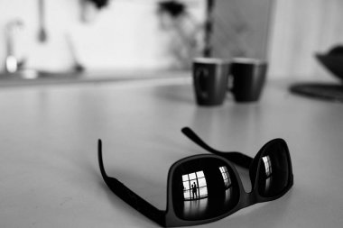 Kucaklaşan bir çiftin güneş gözlüğündeki yansıması