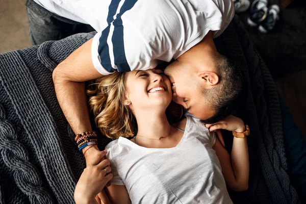 Jeune couple amoureux riant au lit — Photo