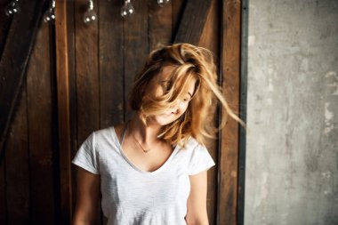 Kız başını sallıyor, saçları uçuşuyor.