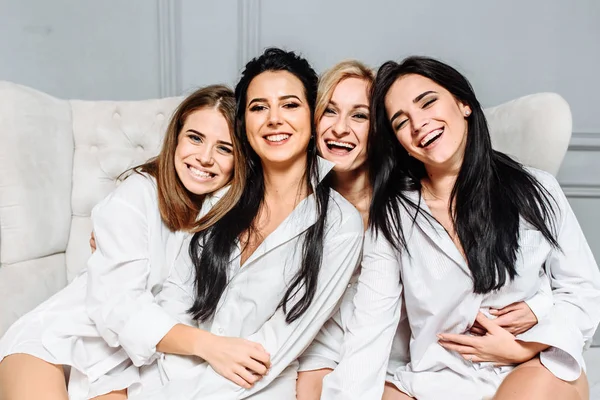 Portrait of several girls in white clothes on a sofa — Stock Photo, Image