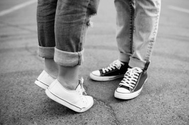 Bir erkek ve spor ayakkabılı bir kızın bacakları..