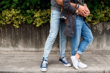 Bir erkek ve spor ayakkabılı bir kızın bacakları..