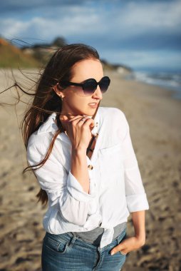 Sahilde sıradan kıyafetler içinde güzel bir kız.