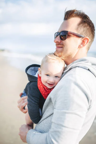 Щаслива сім'я. Тато тримає свого малюка на пляжі. — стокове фото