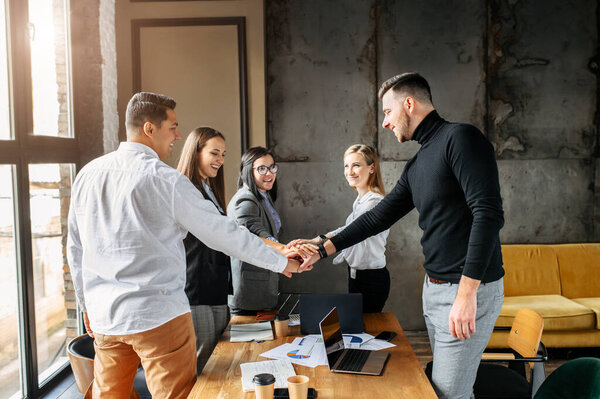 творческие люди в офисных руках, собранных вместе
