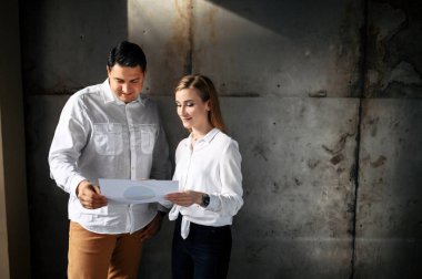 Elinde belgeler olan kadın ve erkek.