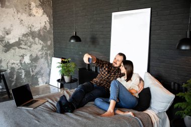 Çift çatı katında yatak odasında selfie çekiyor.