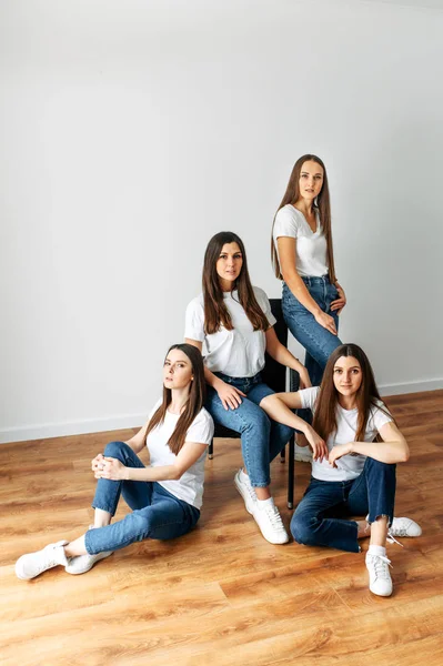 Vier brunette meisjes in witte t-shirts poseren — Stockfoto