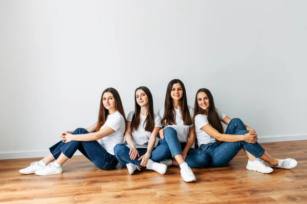 Unge og bekymringsløse jenter sitter på gulvet – stockfoto