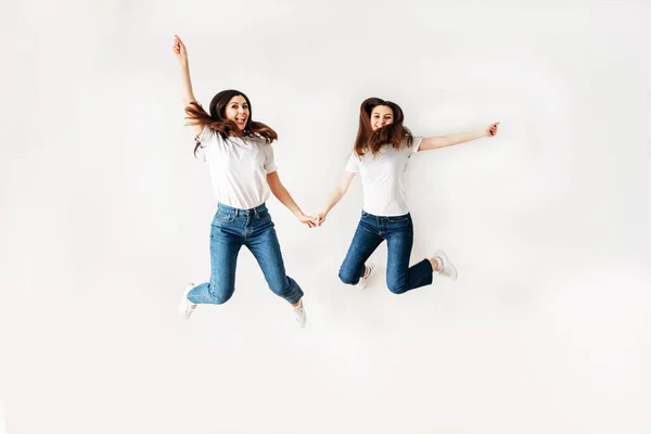 Dos chicas en ropa casual saltar alto — Foto de Stock