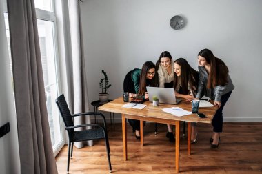 Ofisteki kadınlar dizüstü bilgisayara bakarlar.