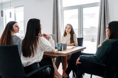 Kadınlar iş arkadaşlarına bir şey söylüyor.