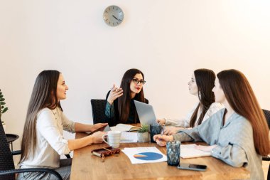 Masadaki ofiste bayan takım var.