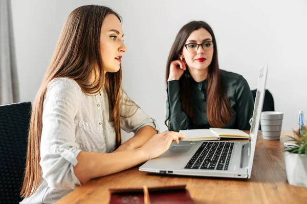 Dos chicas jóvenes en elegante mirada casual a la computadora portátil — Foto de Stock