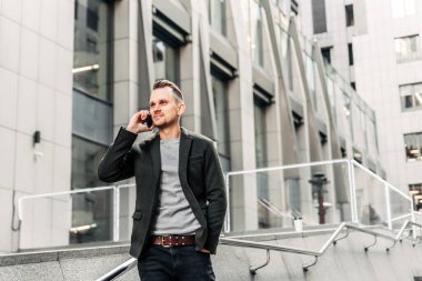 A man stands and speaks on the phone