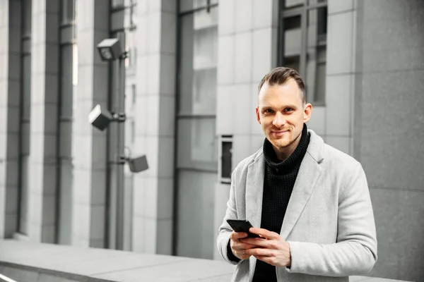 Attrayant gars dans smart casual avec smartphone — Photo