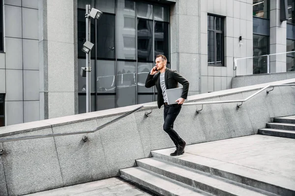 Hombre con un portátil corre por las escaleras a la oficina —  Fotos de Stock