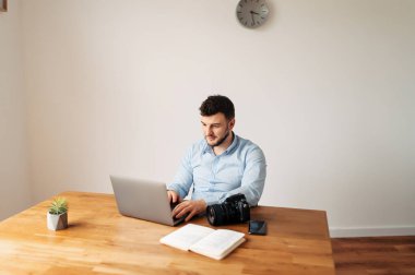 Çekici erkek ofis çalışanı dizüstü bilgisayar kullanıyor.