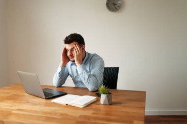 Gömlekli bir ofis çalışanı dikkatlice düşünür.