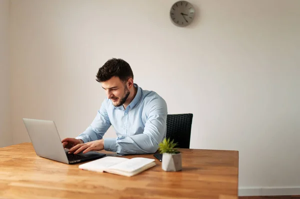 Aantrekkelijke mannelijke kantoormedewerker gebruikt een laptop — Stockfoto