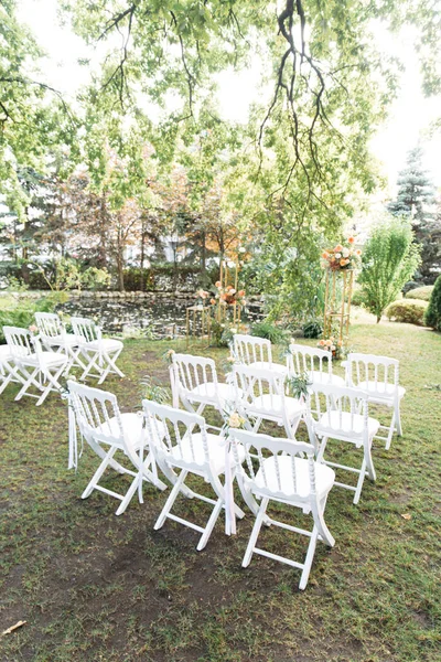 Chaises blanches en bois dans une rangée sur l'herbe — Photo