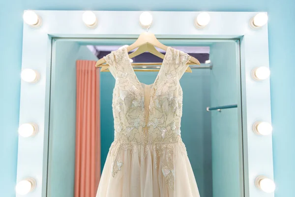 Bridal dress hanging on the dressing room mirror