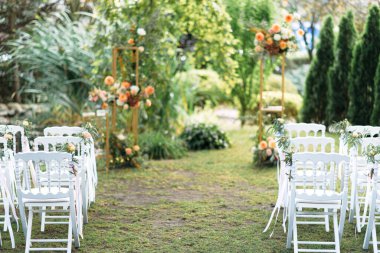 White wooden chairs in a row on the grass