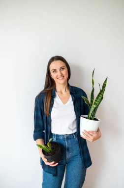 Young woman holds a flower pot in her hands