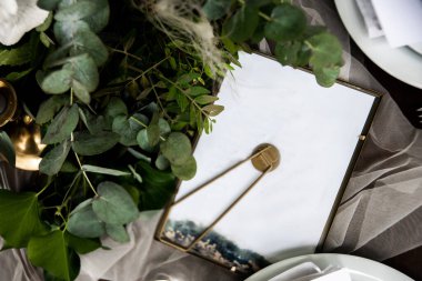 Green branches and frame on festive table