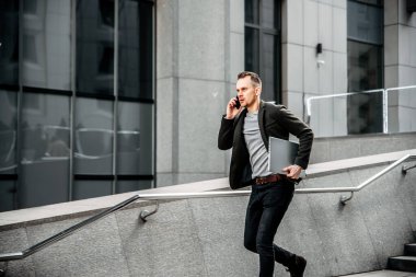 A man with a laptop hurries to a meeting