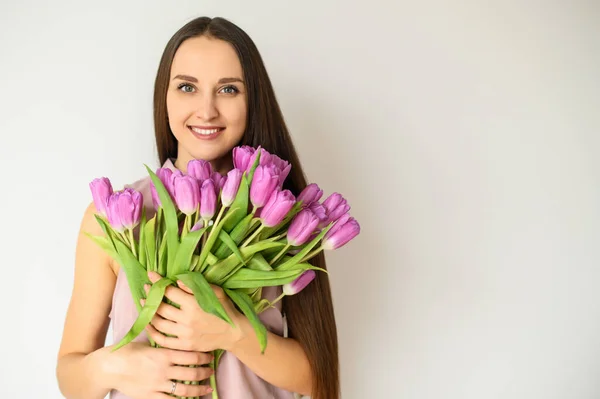 Humor de primavera. Mujer hermosa con tulipanes en el interior — Foto de Stock