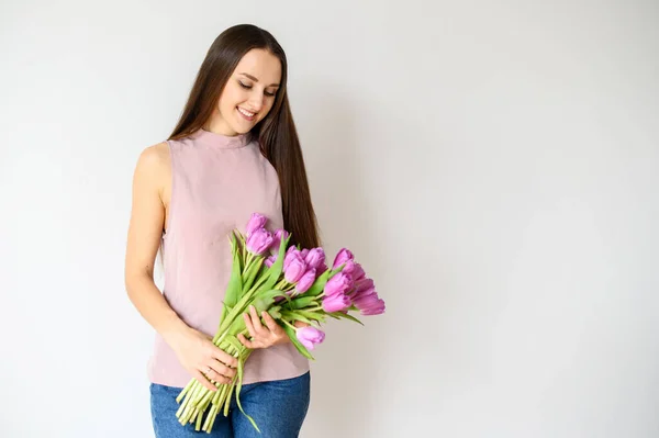 Humor de primavera. Mujer hermosa con tulipanes en el interior — Foto de Stock