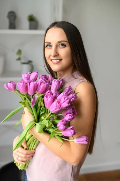 Wiosenny nastrój. Piękna kobieta z tulipanami w środku — Zdjęcie stockowe