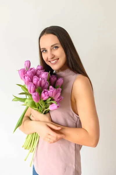 Humor de primavera. Mujer hermosa con tulipanes en el interior — Foto de Stock